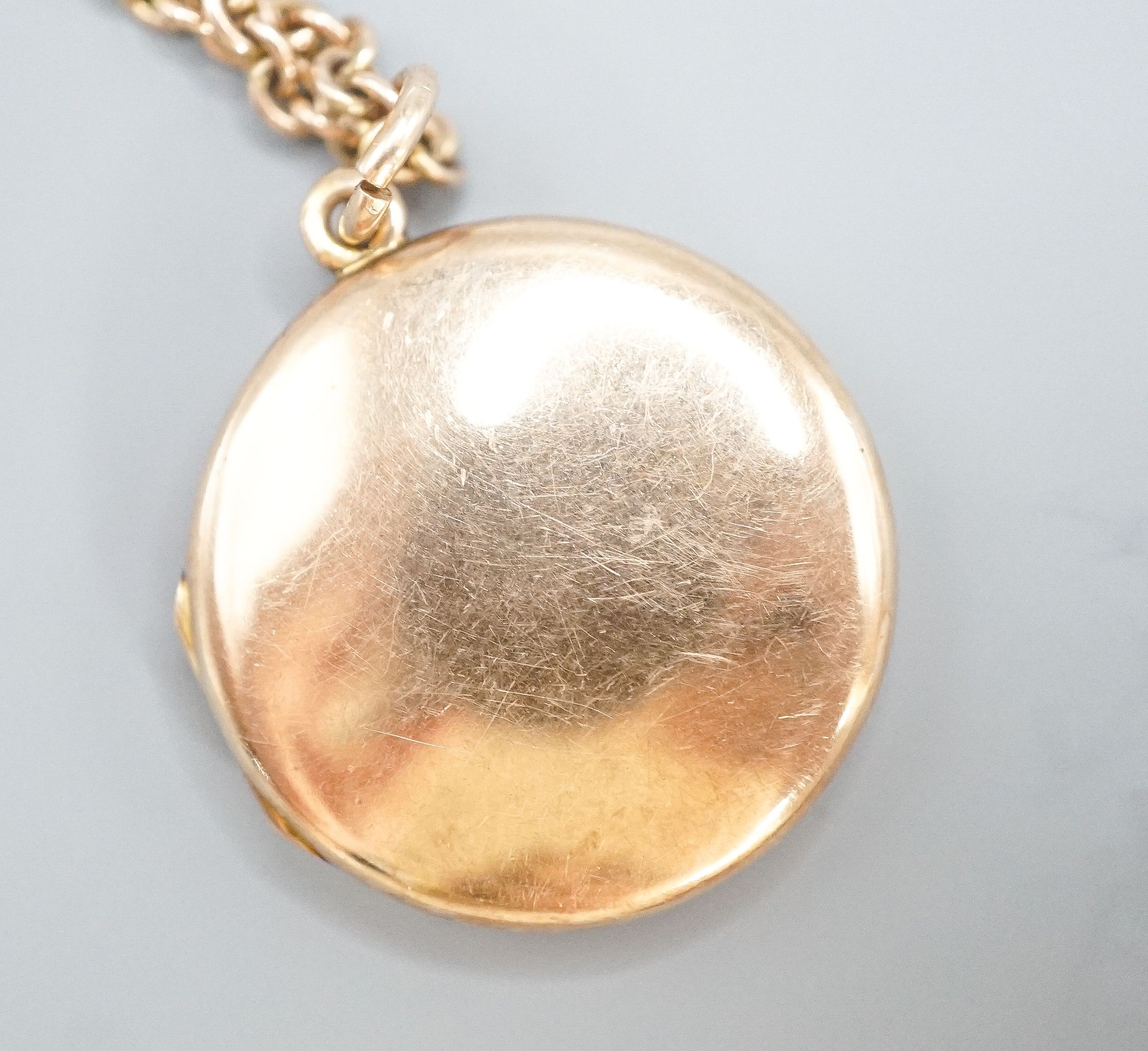 A 9ct circular locket, 26mm, on a 9k chain, 62cm, gross weight 21.2 grams.